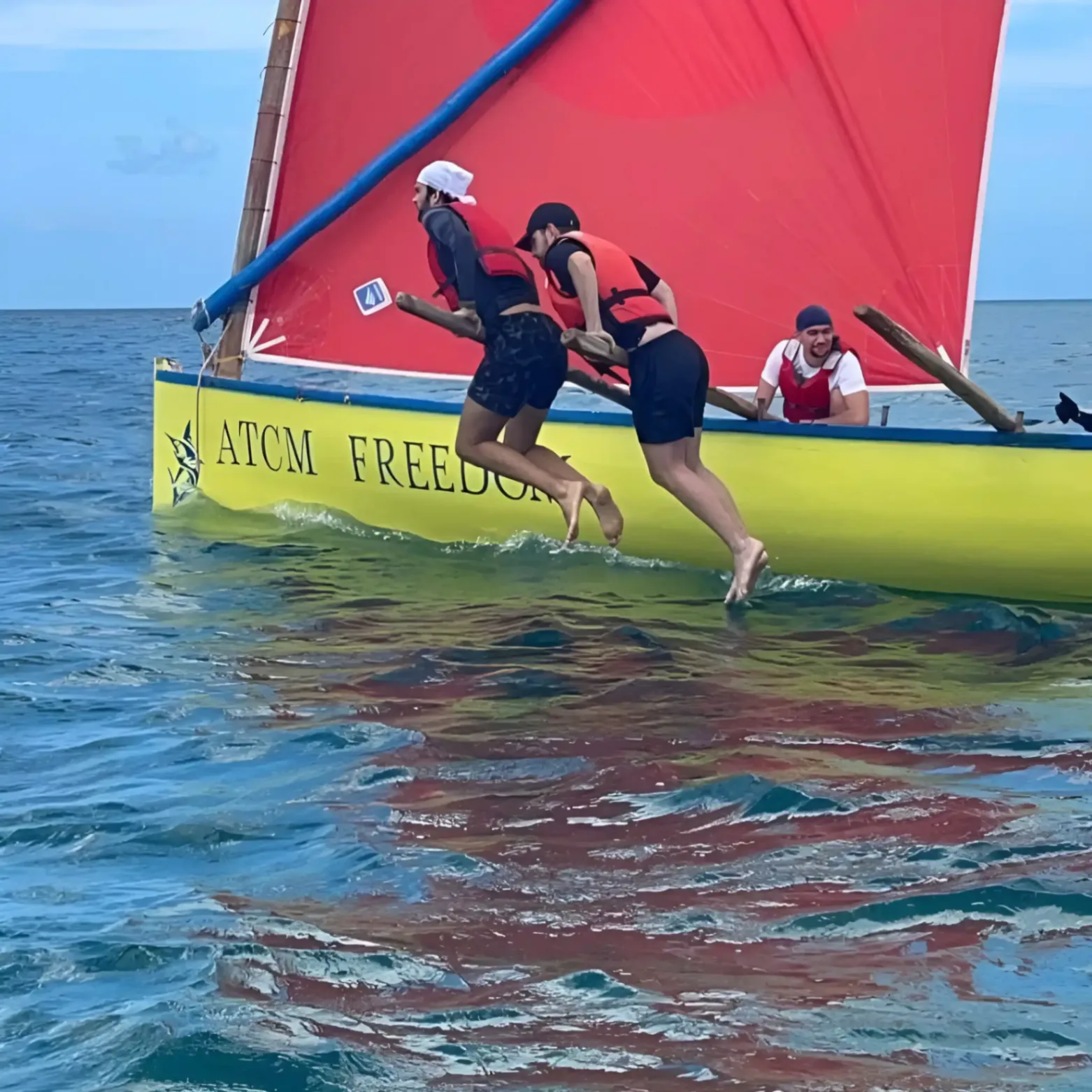 Participants en gilet de sauvetage courant sur le bord d’un bateau traditionnel ATCM Freedom lors d’une activité en mer