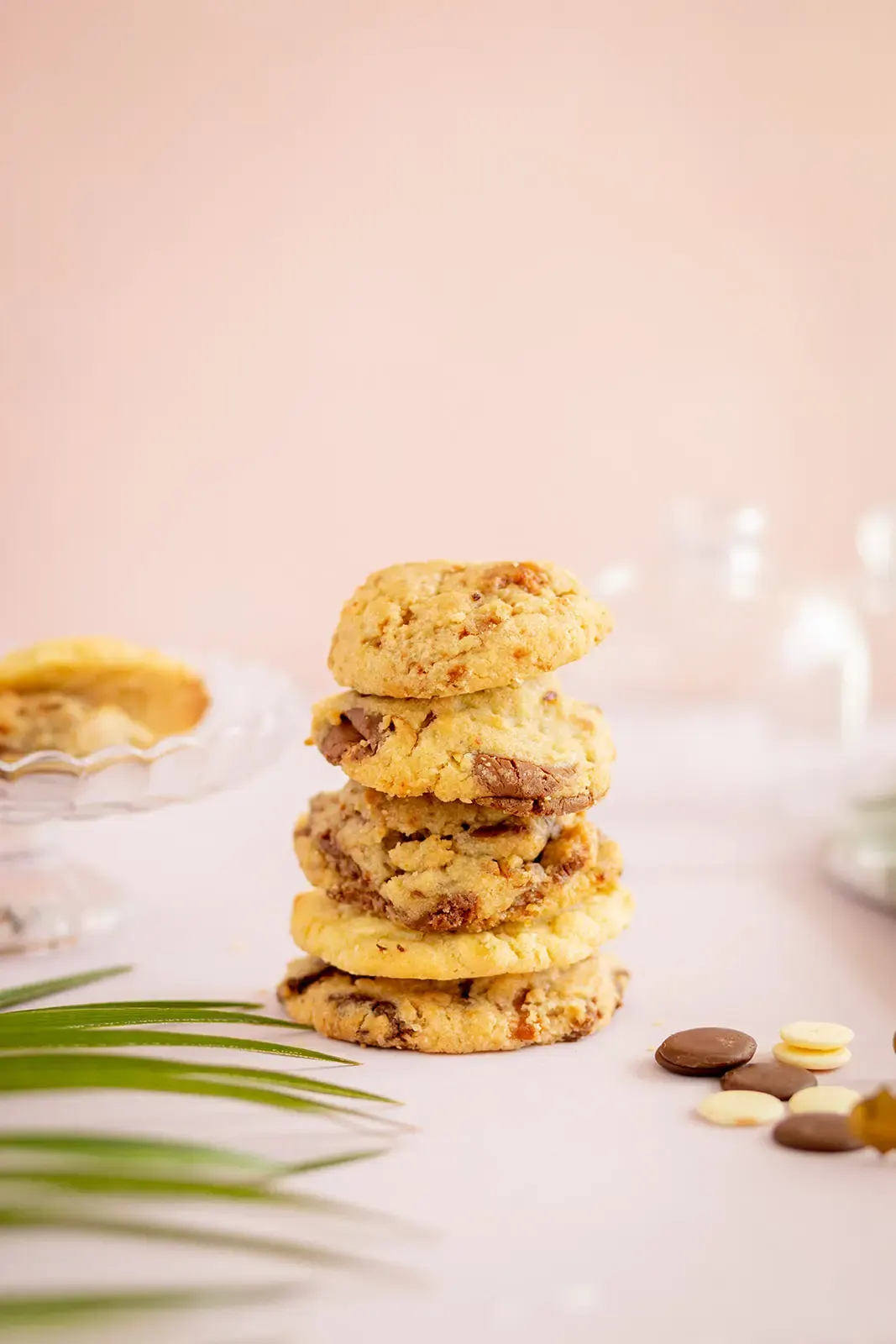 Pile de cookies maison aux pépites de chocolat posée sur une table claire, ambiance douce et pastel.