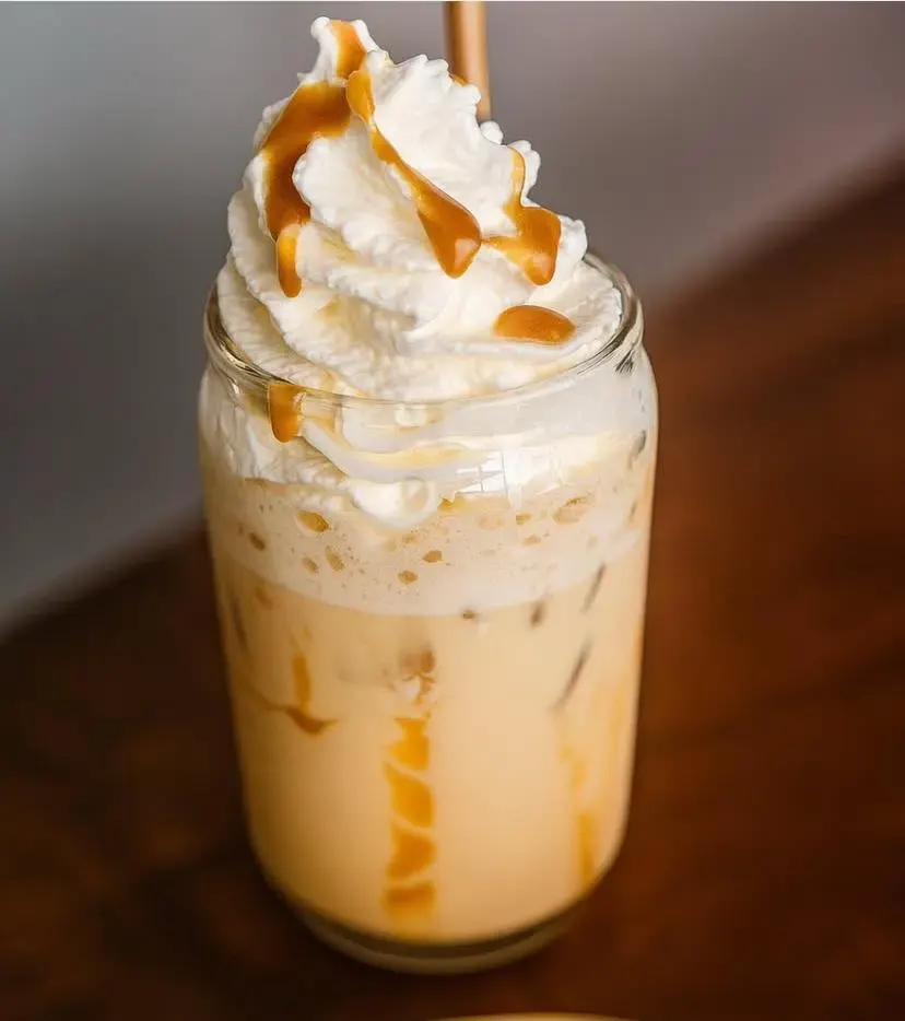 Frappé glacé au caramel avec crème fouettée dans un mason jar, boisson gourmande artisanale.