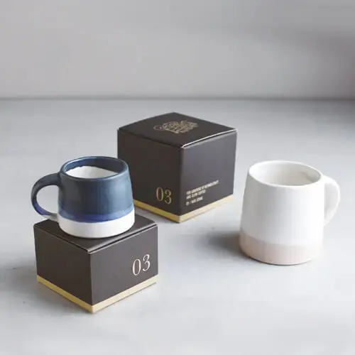 Mugs artisanaux en céramique posés sur des boîtes cadeaux élégantes, design minimaliste.