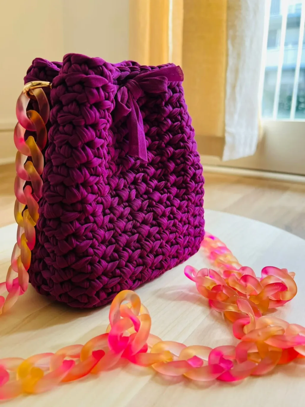 Sac en crochet violet avec chaîne en résine rose et orange, réalisé à la main.