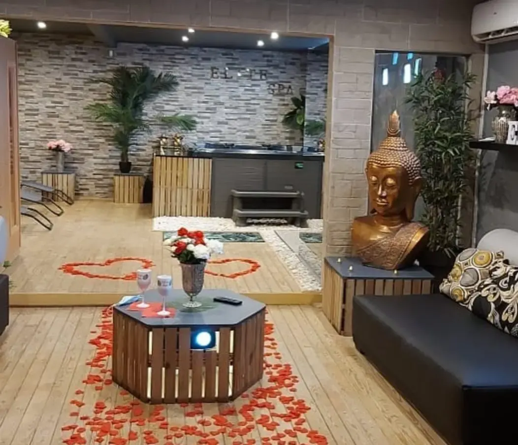 Salle bien-être Elite Spa avec jacuzzi, pétales de roses au sol et ambiance romantique