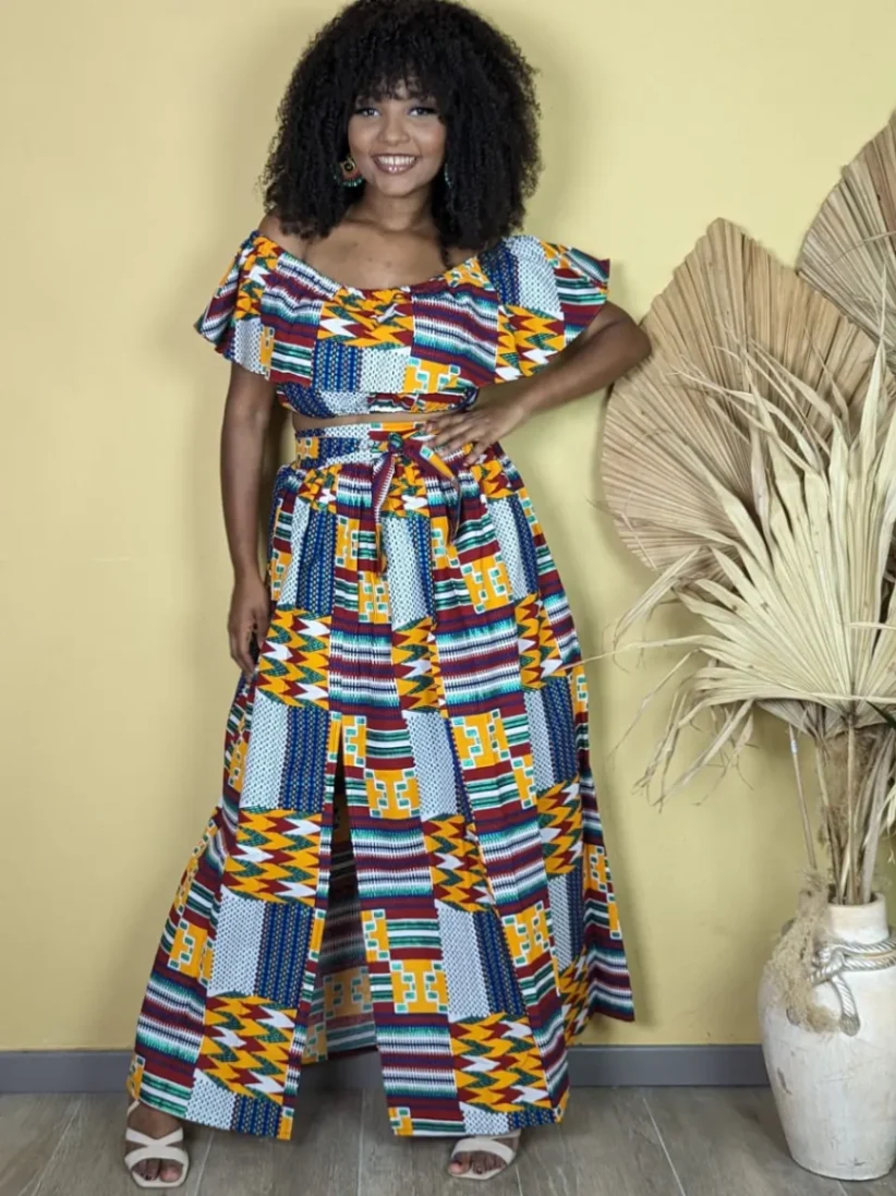 Femme portant un ensemble wax multicolore avec un top à volants et une jupe longue fendue, look africain moderne