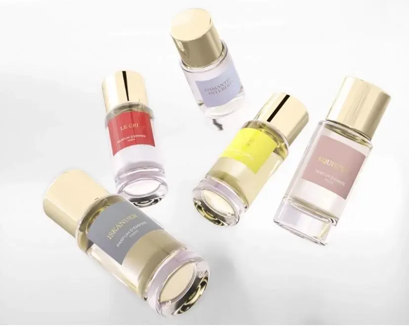 Collection de flacons de parfums minimalistes aux bouchons dorés sur fond clair