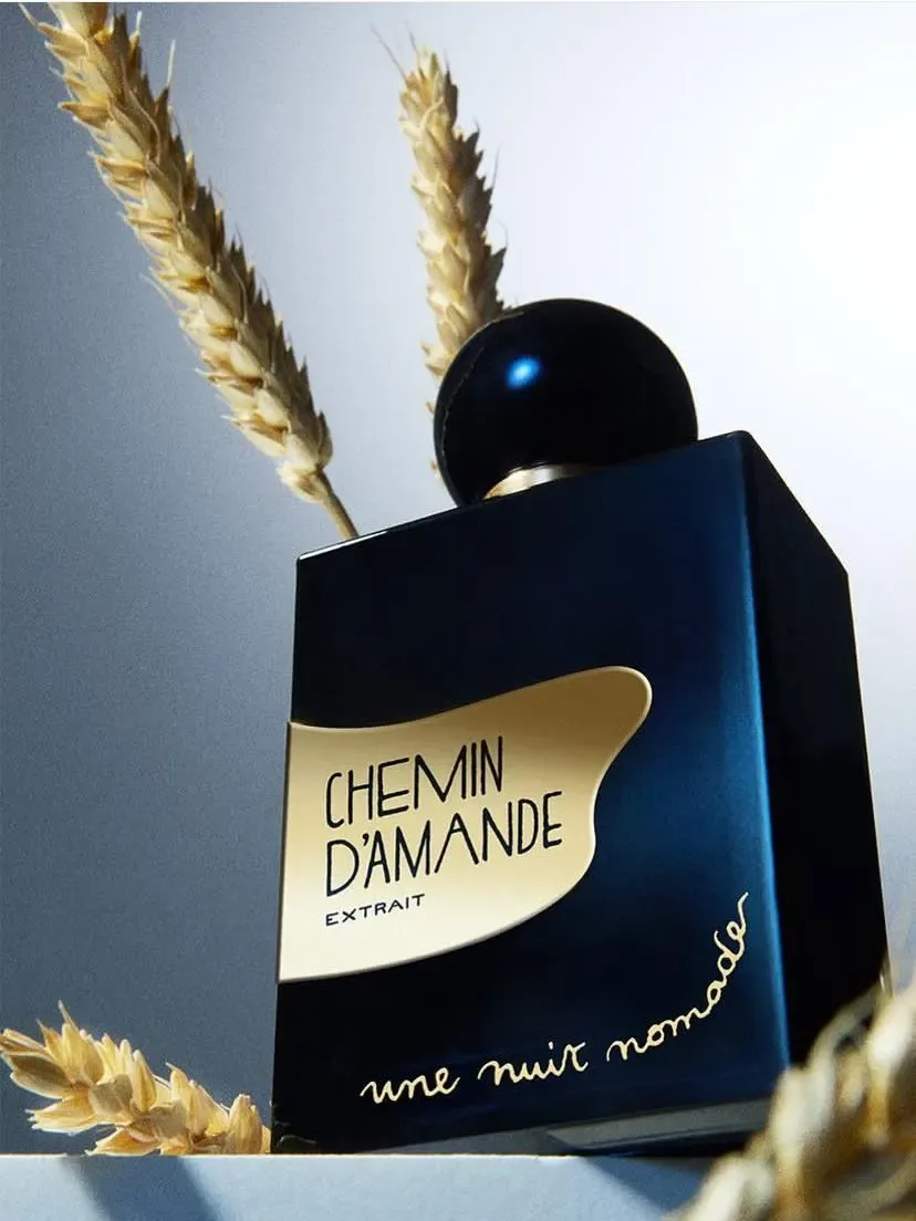 Flacon de parfum Chemin d’Amande en mise en scène artistique avec des épis de blé.