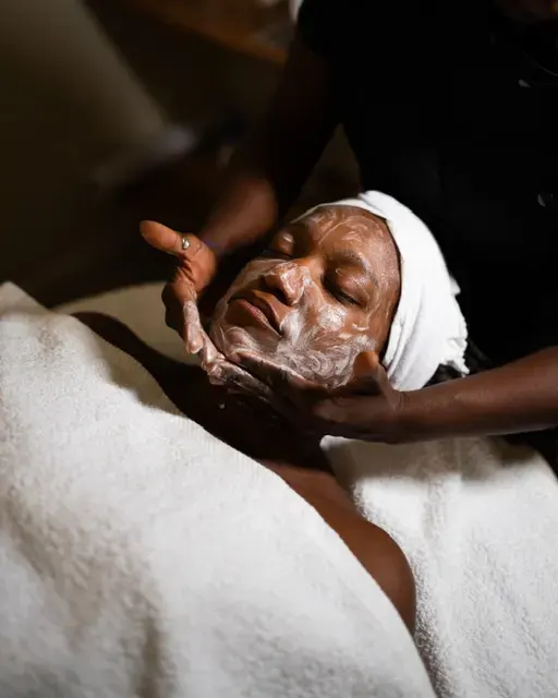 Esthéticienne appliquant un soin moussant sur le visage d’une cliente lors d’un rituel beauté