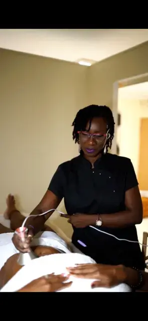 Praticienne réalisant un soin esthétique avec un appareil professionnel dans un centre de beauté