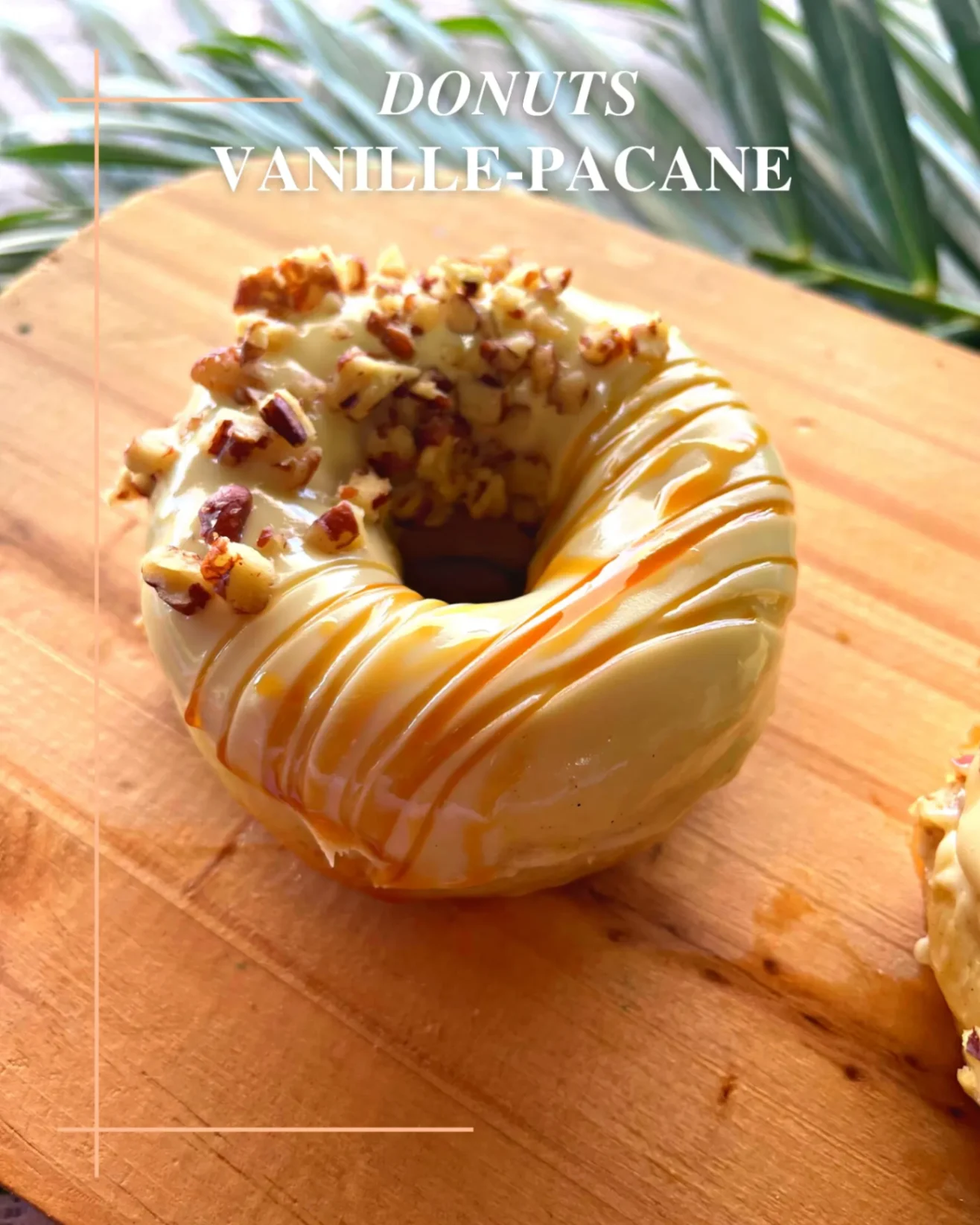 Donut vanille-pacane garni de noix de pécan et nappé de caramel, posé sur une planche en bois