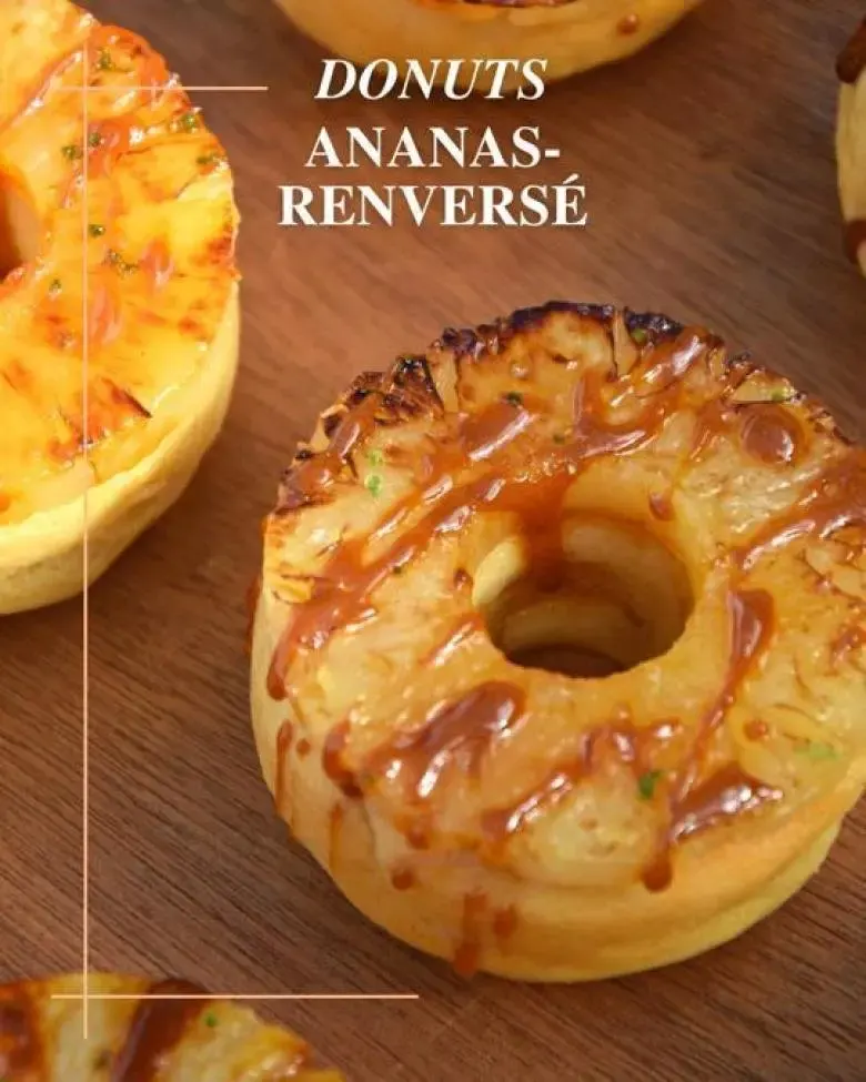Donut ananas renversé nappé de caramel, pâtisserie tropicale présentée sur une planche en bois.