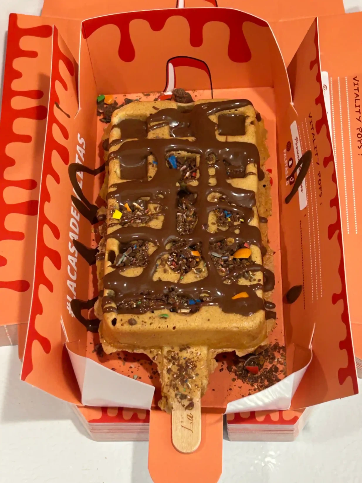 Gaufre en bâtonnet généreusement nappée de chocolat et toppings colorés, servie chez La Casa de Paletas.