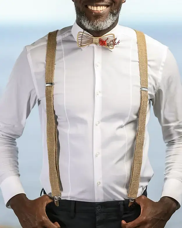 Homme élégant portant une chemise blanche et des bretelles naturelles lors d’un événement