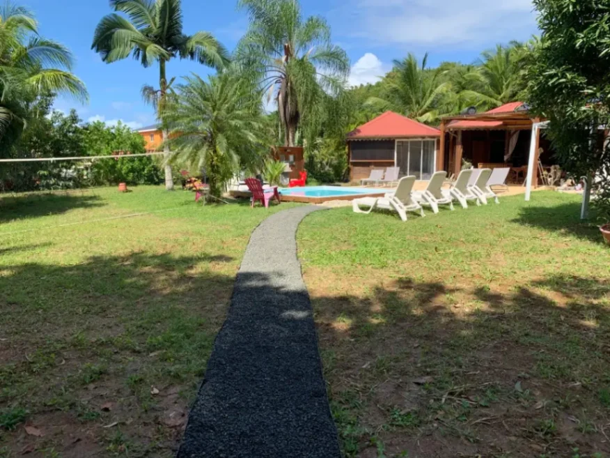 Espace jardin de la Suite Lagoon avec piscine, transats et terrasse en Martinique