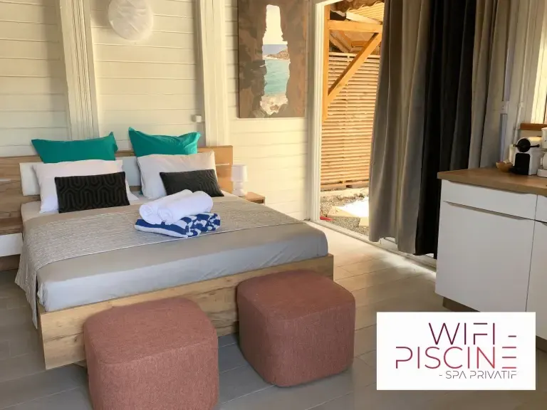 Chambre moderne avec lit double, kitchenette et accès spa privatif en Martinique