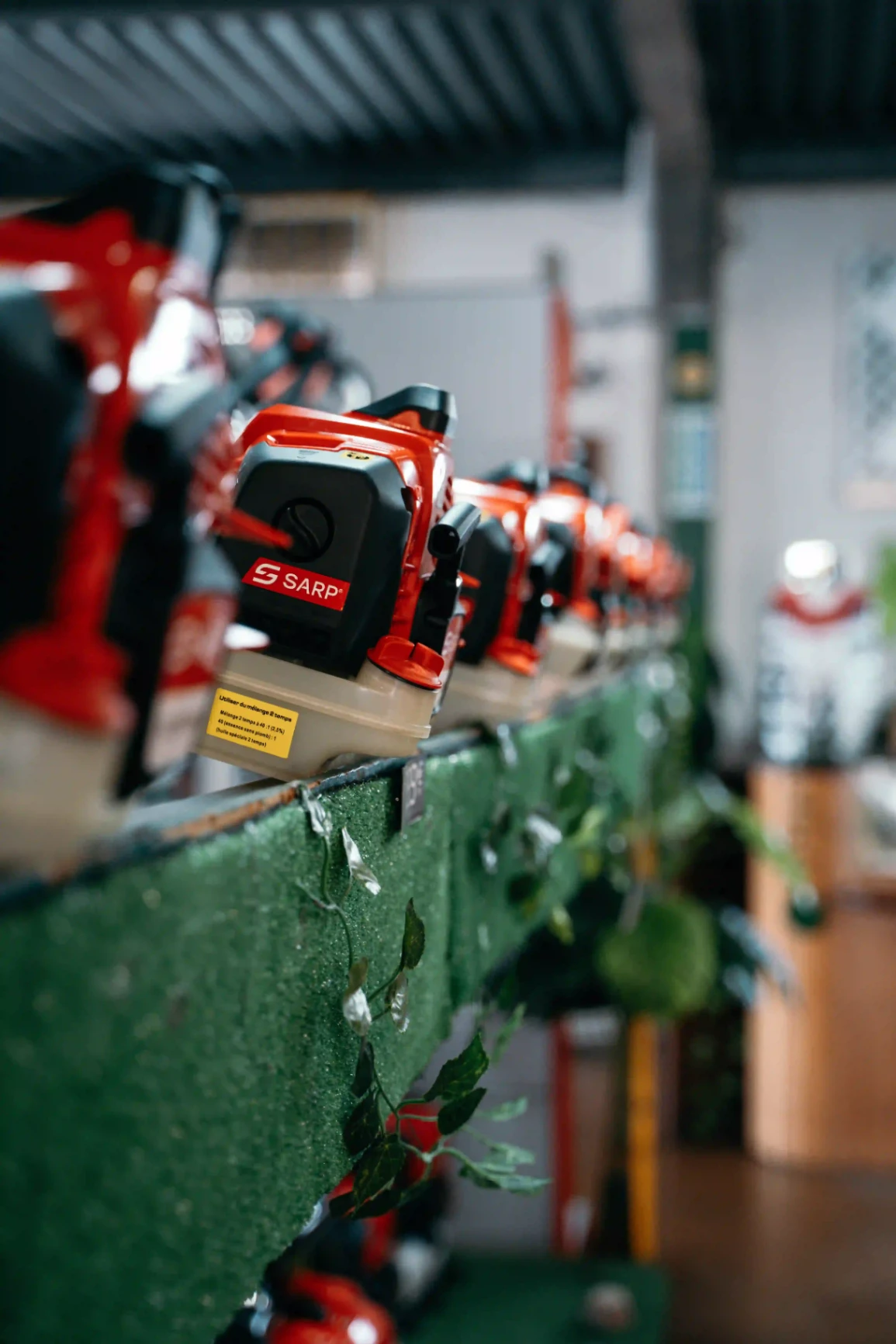 Mur d’exposition présentant plusieurs outils motorisés Maruyama dans une boutique.