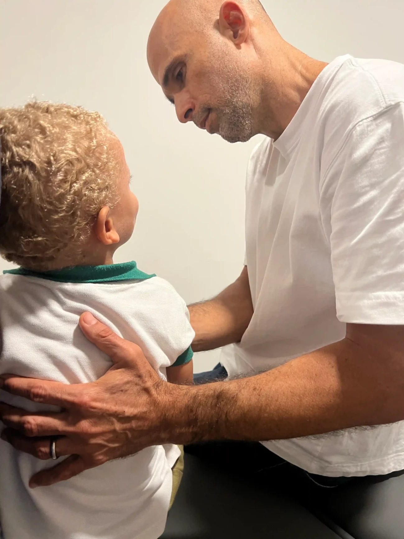 Ostéopathe réalisant une séance avec un jeune enfant assis, dans un cadre apaisant