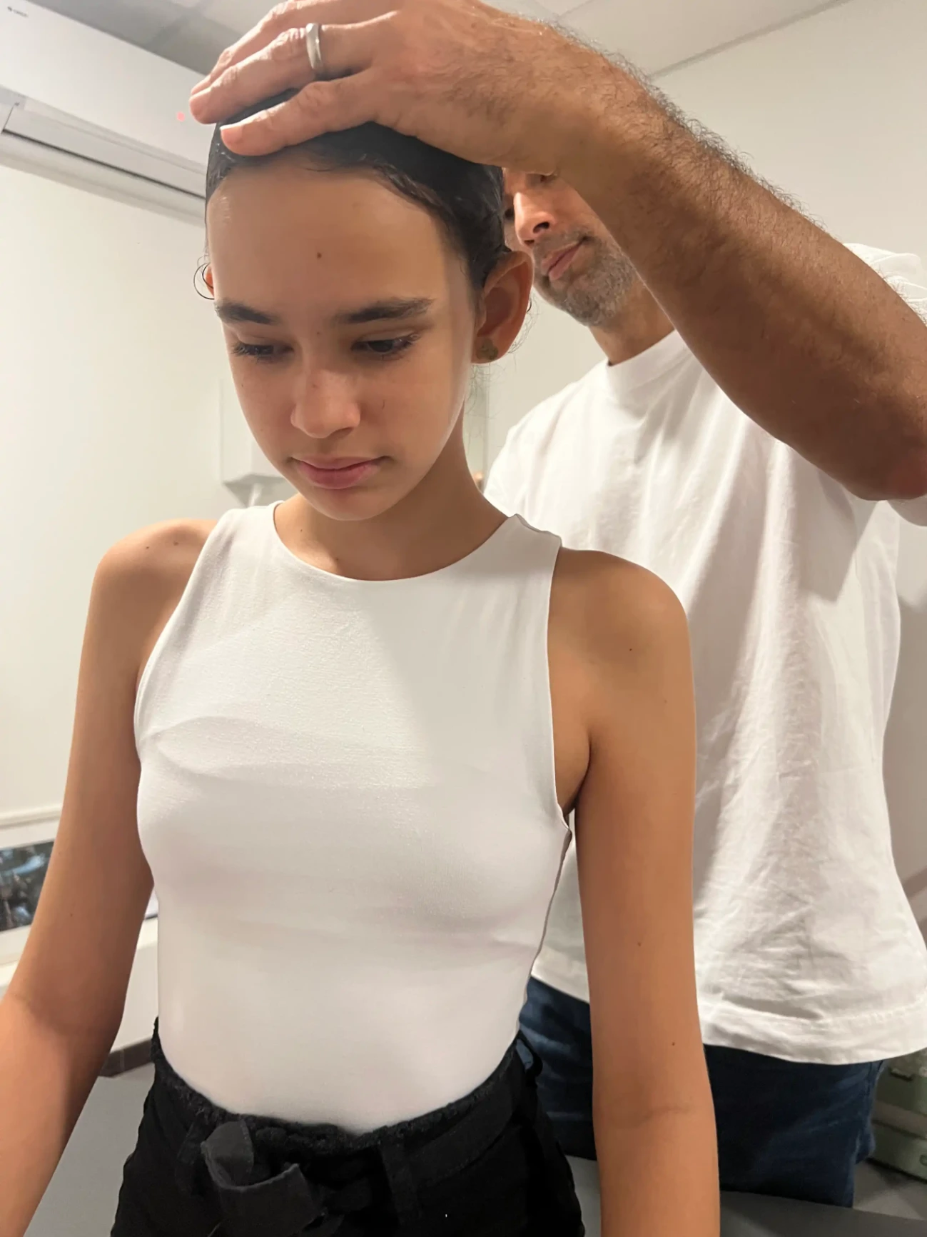 Ostéopathe ajustant la posture d’une adolescente lors d’une séance individuelle.