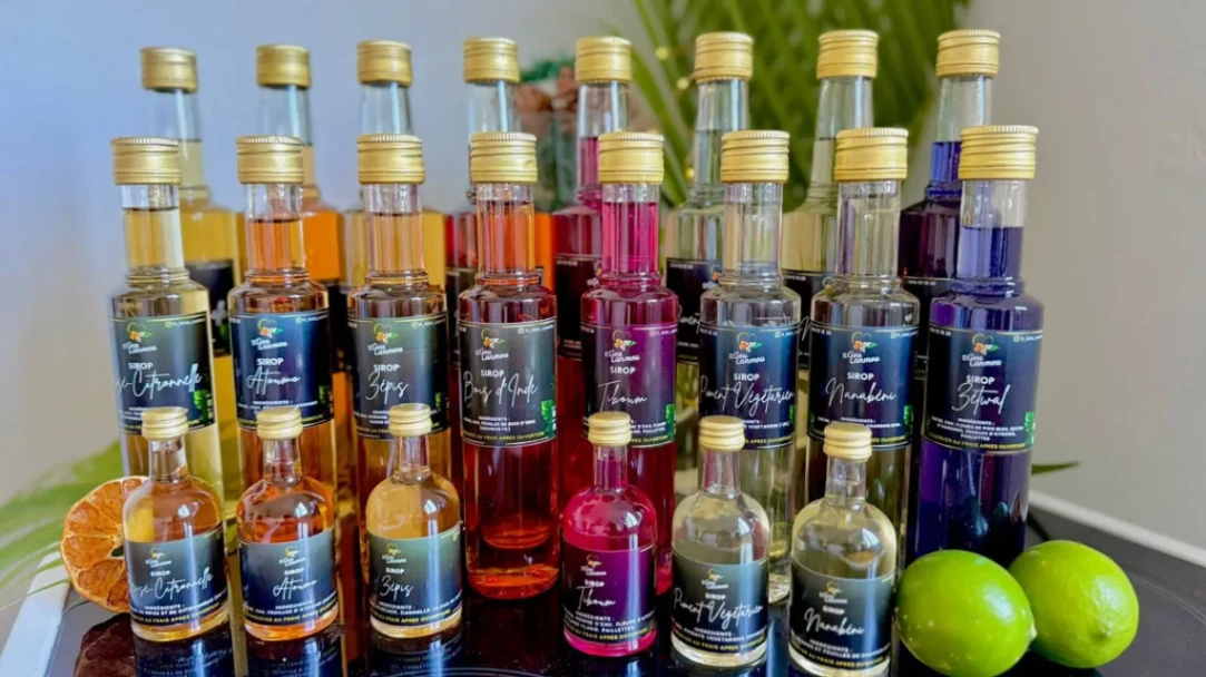 Collection de sirops artisanaux aux saveurs tropicales Ti Gou Lanmou, présentés en plusieurs bouteilles de tailles différentes