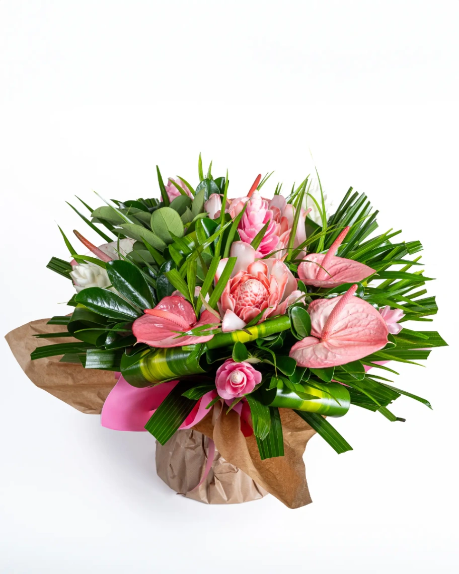 Bouquet tropical composé d’anthuriums roses, de fleurs de gingembre et de feuillages verts, présenté sur fond blanc.
