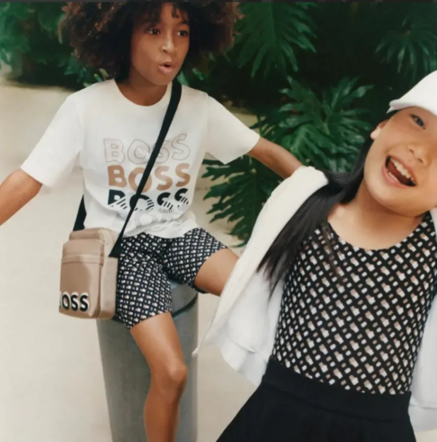 Enfants en tenue urbaine moderne, exprimant dynamisme et style dans un environnement extérieur.