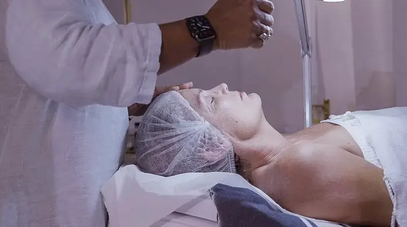 Soin du visage en institut esthétique, cliente allongée pendant un traitement relaxant et professionnel.