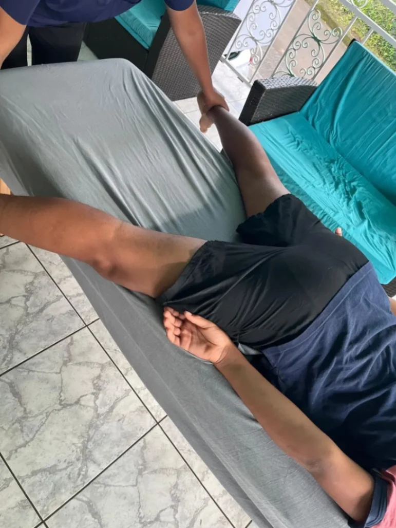 Mobilisation douce de la jambe lors d’un massage thérapeutique visant à améliorer la souplesse et la récupération musculaire.