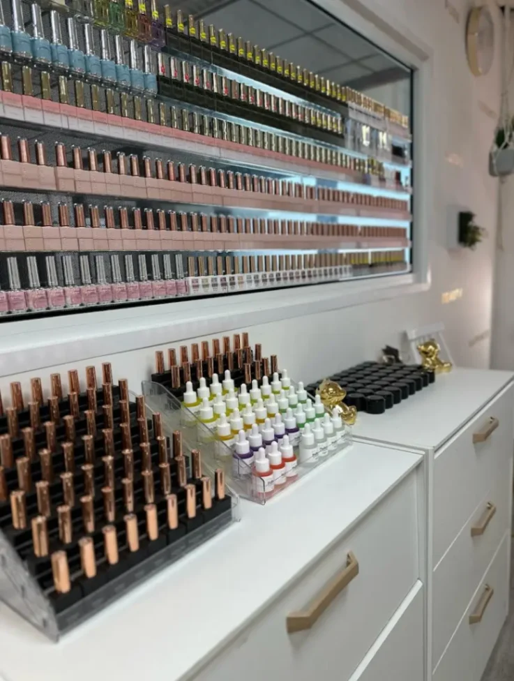 Présentoir de vernis et produits d’onglerie professionnels soigneusement organisés dans un institut de beauté.