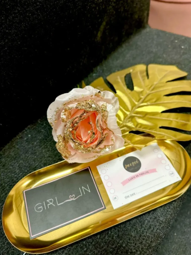 Plateau d’accueil client en institut de beauté avec carte de fidélité, carte de visite et décoration élégante.