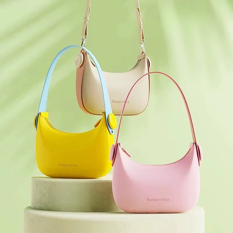 Trois mini sacs à main pour femme aux couleurs pastel jaune, rose et beige, présentés sur des socles décoratifs