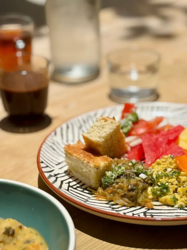 Assiette de dégustation composée de légumes marinés, salade et morceaux de focaccia sur une table de restaurant