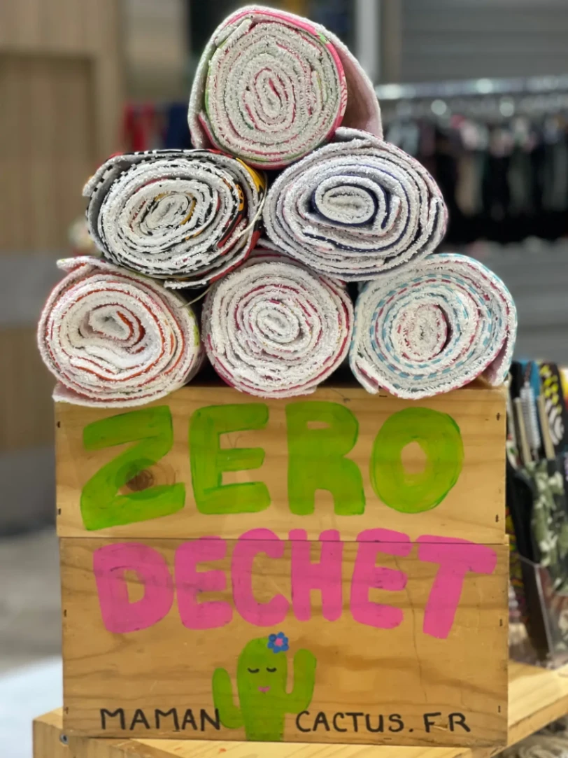 Lingettes réutilisables zéro déchet en tissu présentées sur un stand Maman Cactus.