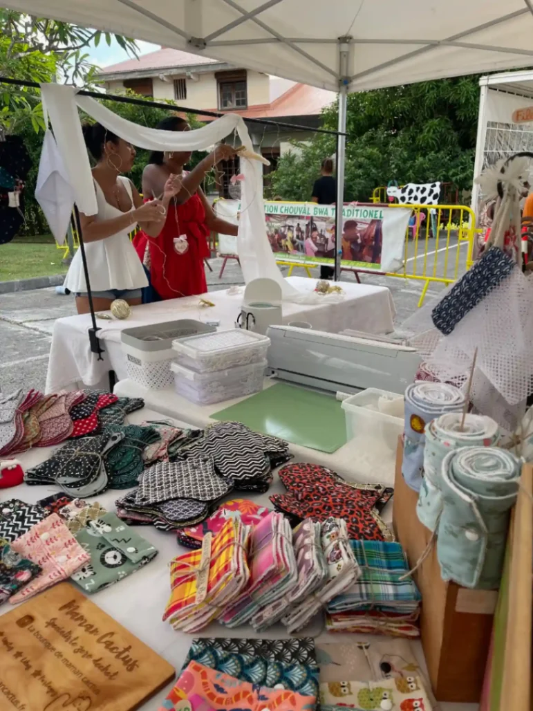 Création artisanale sur un stand de marché en Martinique avec accessoires textiles faits main.