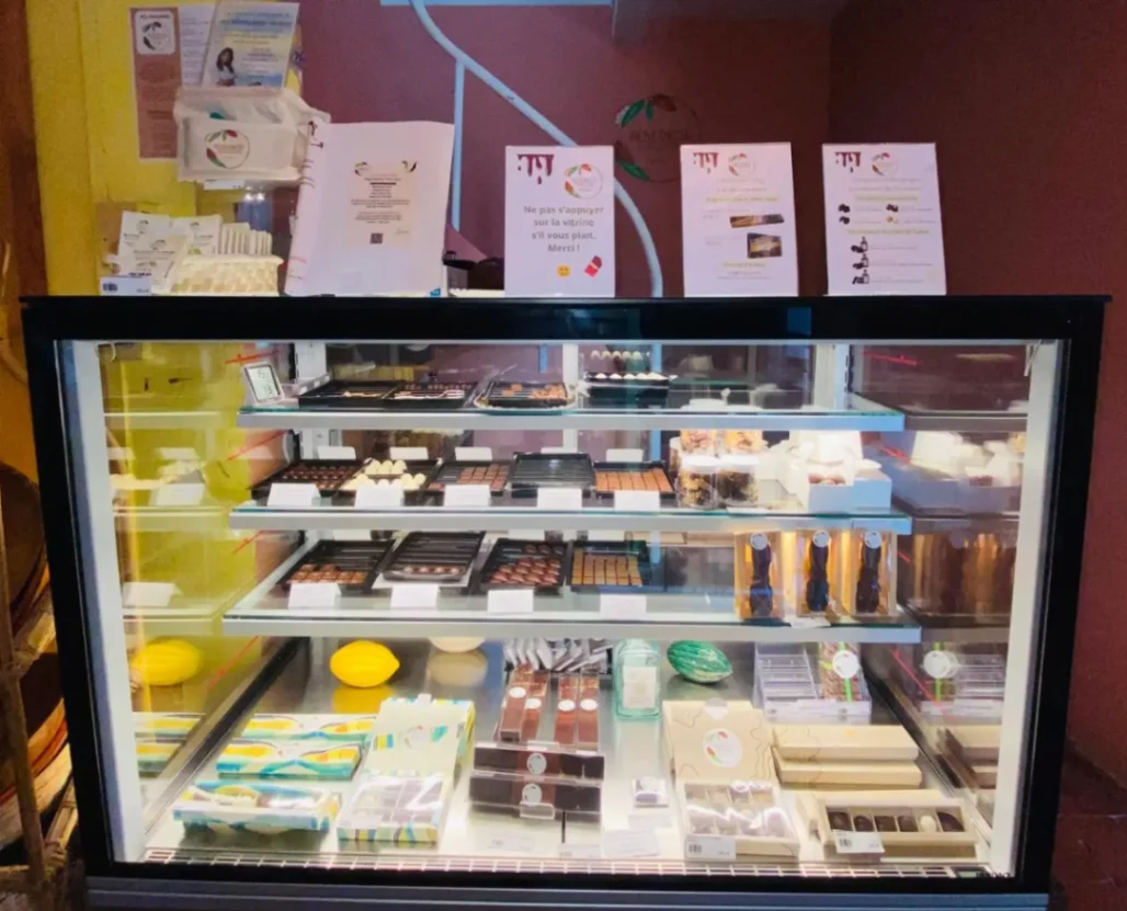 Vitrine réfrigérée présentant des chocolats artisanaux et gourmandises en Martinique.