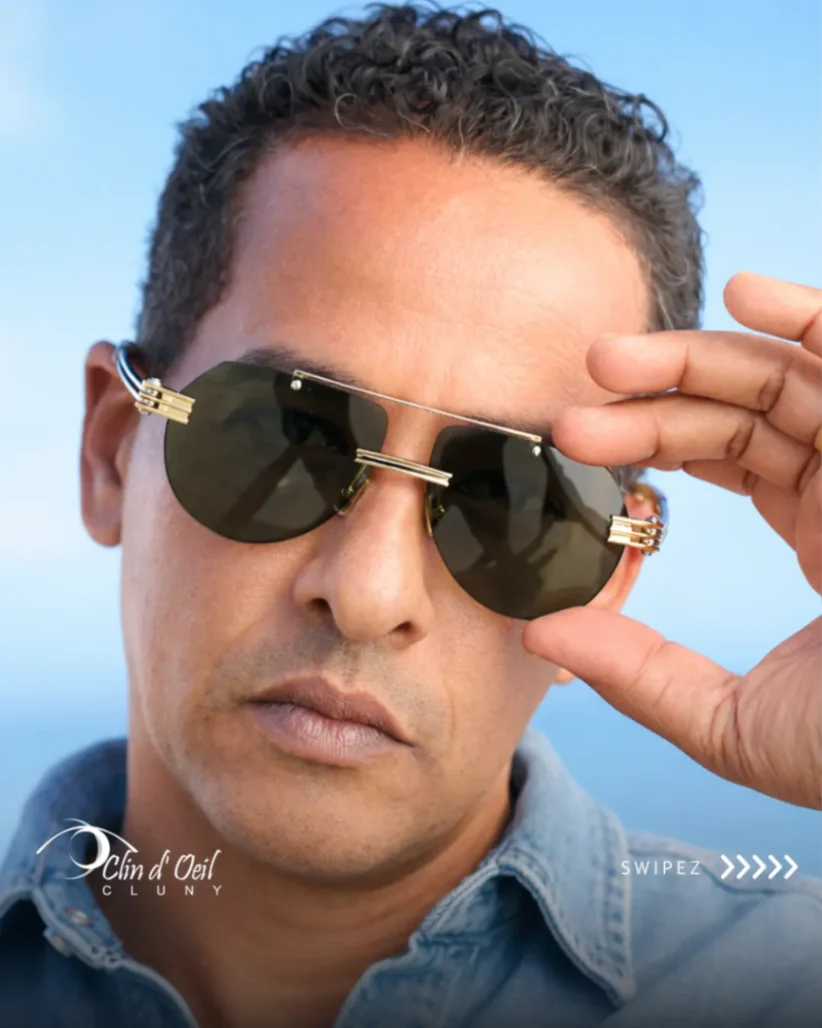 Homme portant des lunettes de soleil noires sans contour avec détails dorés, collection optique Clin d'Œil Cluny.