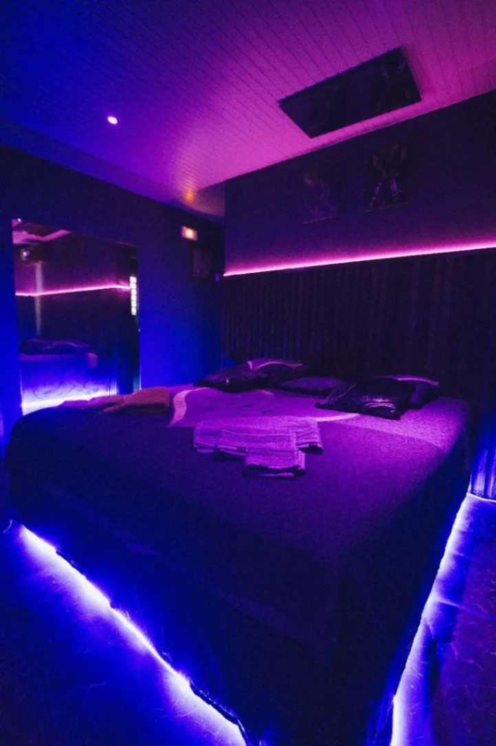 Chambre romantique avec lit king size, éclairage LED d'ambiance et décoration intimiste pour une escapade en couple.
