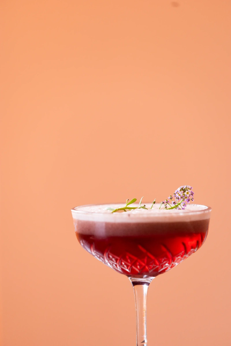 Cocktail signature aux notes fruitées servi dans un verre à cocktail élégant dans un restaurant en Martinique.